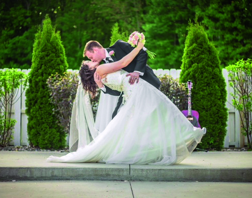 Bride and groom kissing in pavilion at wedding ceremony.